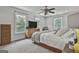 Serene bedroom with three windows and a ceiling fan, with comfortable bedding and neutral colors at 106 Lanyard Bnd, Peachtree City, GA 30269