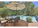 Refreshing pool area with an umbrella and comfortable outdoor seating on a wooden deck at 106 Lanyard Bnd, Peachtree City, GA 30269