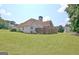 Large backyard with a green lawn and two-story home with a chimney and fence at 115 Sunderland Cir, Fayetteville, GA 30215