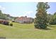 Green backyard lawn with partial view of two-story home with a chimney and a pergola at 115 Sunderland Cir, Fayetteville, GA 30215