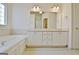 Bathroom with double vanity, soaking tub, tile floor, and bright overhead and natural lighting at 115 Sunderland Cir, Fayetteville, GA 30215