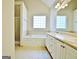 Bright bathroom featuring a soaking tub, tiled floor, double vanity, and a window at 115 Sunderland Cir, Fayetteville, GA 30215