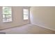 A neutral bedroom offers plush carpeting and dual windows for ample light at 115 Sunderland Cir, Fayetteville, GA 30215