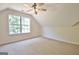 Bright carpeted bedroom with angled ceilings, a ceiling fan and large window at 115 Sunderland Cir, Fayetteville, GA 30215