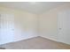 A light filled bedroom with neutral carpet and two doors at 115 Sunderland Cir, Fayetteville, GA 30215