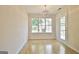 Dining room with hardwood floors, modern lighting fixture and a bright window overlooking the backyard at 115 Sunderland Cir, Fayetteville, GA 30215