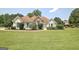Inviting single-story home with manicured lawn, stone accents, and charming teal shutters at 115 Sunderland Cir, Fayetteville, GA 30215