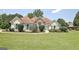 Inviting single-story home with manicured lawn, stone accents, and charming teal shutters at 115 Sunderland Cir, Fayetteville, GA 30215