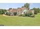 Landscaped home featuring stone accents, arched window, and concrete walkway at 115 Sunderland Cir, Fayetteville, GA 30215