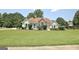 Inviting single-story home with manicured lawn, stone accents, and charming teal shutters at 115 Sunderland Cir, Fayetteville, GA 30215