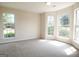 Bright, airy room featuring neutral carpet and lots of natural light from three large windows at 115 Sunderland Cir, Fayetteville, GA 30215