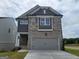 Two-story home showcasing gray brick, stone accents, gray siding, and a two-car garage at 38 Avian Way # 126B, Auburn, GA 30011