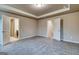 Spacious bedroom with grey carpet, crown molding and adjoining bathroom and closet entrances at 40 Avian Way # 127B, Auburn, GA 30011