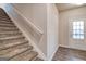 Entryway features staircase with carpet, white handrail, wood floors, and natural light at 40 Avian Way # 127B, Auburn, GA 30011