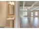 Powder room featuring pedestal sink, and view into spacious living area with coffered ceiling and hardwood floors at 40 Avian Way # 127B, Auburn, GA 30011