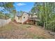 Exterior view of the home featuring a spacious backyard, lush trees, and a wooden deck at 1911 Geyser Trce, Lawrenceville, GA 30044