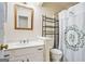 Cozy bathroom with white cabinets, decorative shower curtain, and framed mirror at 1911 Geyser Trce, Lawrenceville, GA 30044