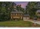 Brick home at dusk featuring a manicured lawn, symmetrical design, and a two-car garage at 1911 Geyser Trce, Lawrenceville, GA 30044