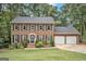 Charming brick home with a well-manicured front yard, black shutters, and a two-car garage at 1911 Geyser Trce, Lawrenceville, GA 30044