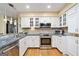 Well-lit kitchen featuring stainless steel appliances, granite countertops and white cabinets at 1911 Geyser Trce, Lawrenceville, GA 30044