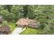 Aerial view of charming home with a two-car garage and surrounded by mature trees at 115 Club Cir, Stockbridge, GA 30281