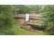 Backyard view featuring a brick home with a wooden deck and stairs to a concrete slab at 115 Club Cir, Stockbridge, GA 30281