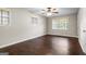 Bedroom features dark vinyl wood floors, neutral paint, two windows and a ceiling fan at 115 Club Cir, Stockbridge, GA 30281