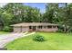 Charming home featuring a stone accent wall, two-car garage, and well-maintained front yard at 115 Club Cir, Stockbridge, GA 30281