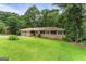Traditional house with a spacious front lawn, attached garage and lovely trees at 115 Club Cir, Stockbridge, GA 30281