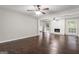 Open-concept living room with hardwood floors, a white brick fireplace, and modern ceiling fans at 115 Club Cir, Stockbridge, GA 30281