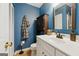 Stylish bathroom with blue walls, a white vanity, and a black accent cabinet for storage at 2031 Dennis Pl, Buford, GA 30519