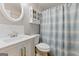 Bright bathroom with white vanity, marble accents, and a shower with a blue striped curtain at 2031 Dennis Pl, Buford, GA 30519