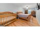 Spacious bedroom with a wooden crib, hardwood floors, and ample natural light at 2031 Dennis Pl, Buford, GA 30519