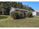 Single-story home with brick and vinyl siding, surrounded by lush green lawn and mature plantings at 5575 Pine Gate Dr, Atlanta, GA 30349