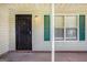 Close up of the front porch with a secure black door, exterior light and green shutters at 5575 Pine Gate Dr, Atlanta, GA 30349