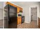 Functional kitchen with wood cabinets, black appliances, and vinyl floors at 5575 Pine Gate Dr, Atlanta, GA 30349