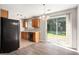 Well-lit kitchen with wood cabinets, black appliances, and sliding doors to the outside at 5575 Pine Gate Dr, Atlanta, GA 30349
