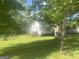 Spacious backyard surrounded by mature trees with a glimpse of the home's exterior at 4109 Francis Ne St, Covington, GA 30014
