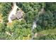 An aerial view showcases the home nestled on a wooded lot with a stream running through the backyard at 177 Selfridge Rd, Mcdonough, GA 30252