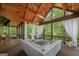 Covered back porch with vaulted wood ceiling, fan, white furniture, and wooded view at 177 Selfridge Rd, Mcdonough, GA 30252
