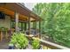 Upstairs porch showcases seating and wooded scenery with planter in the foreground at 177 Selfridge Rd, Mcdonough, GA 30252