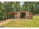 Exterior view of wooden barn with sliding doors and attached shed, set on a grassy area at 177 Selfridge Rd, Mcdonough, GA 30252