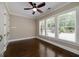 Bright bedroom features dark hardwood floors, three windows with blinds, and a ceiling fan at 177 Selfridge Rd, Mcdonough, GA 30252