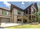 Exterior view featuring the deck, lower level, garage, and well-maintained lawn at 177 Selfridge Rd, Mcdonough, GA 30252