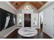 Bright foyer features a wooden ceiling, large paintings, and a round decorative table for a luxurious entry at 177 Selfridge Rd, Mcdonough, GA 30252
