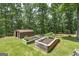 Exterior view of raised garden beds, a shed, and mature trees on a beautiful, grassy lot at 177 Selfridge Rd, Mcdonough, GA 30252