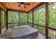 Outdoor hot tub on covered back porch with wooden ceiling and wooded view at 177 Selfridge Rd, Mcdonough, GA 30252