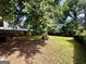Spacious backyard featuring a large shade tree, green grass, and a wooden fence creating a private outdoor space at 1511 Walker Ave, Atlanta, GA 30337