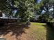 A view of a spacious backyard with lush greenery and a large shade tree at 1511 Walker Ave, Atlanta, GA 30337
