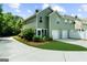 Exterior view of home featuring green siding, a driveway and manicured landscaping at 397 Cypher Dr, Suwanee, GA 30024